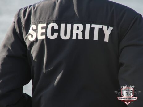 A person wearing a black jacket with the word "SECURITY" printed in large white letters on the back.